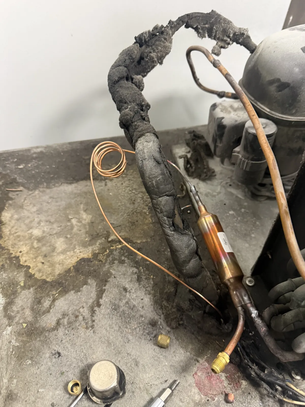 A burned-out commercial refrigeration compressor being diagnosed by Vice Mechanical